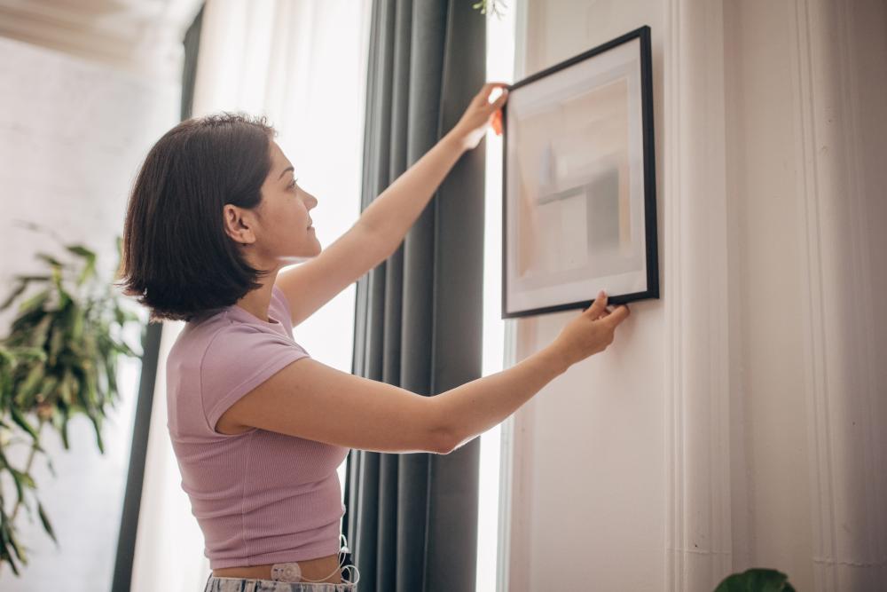 woman hanging frame